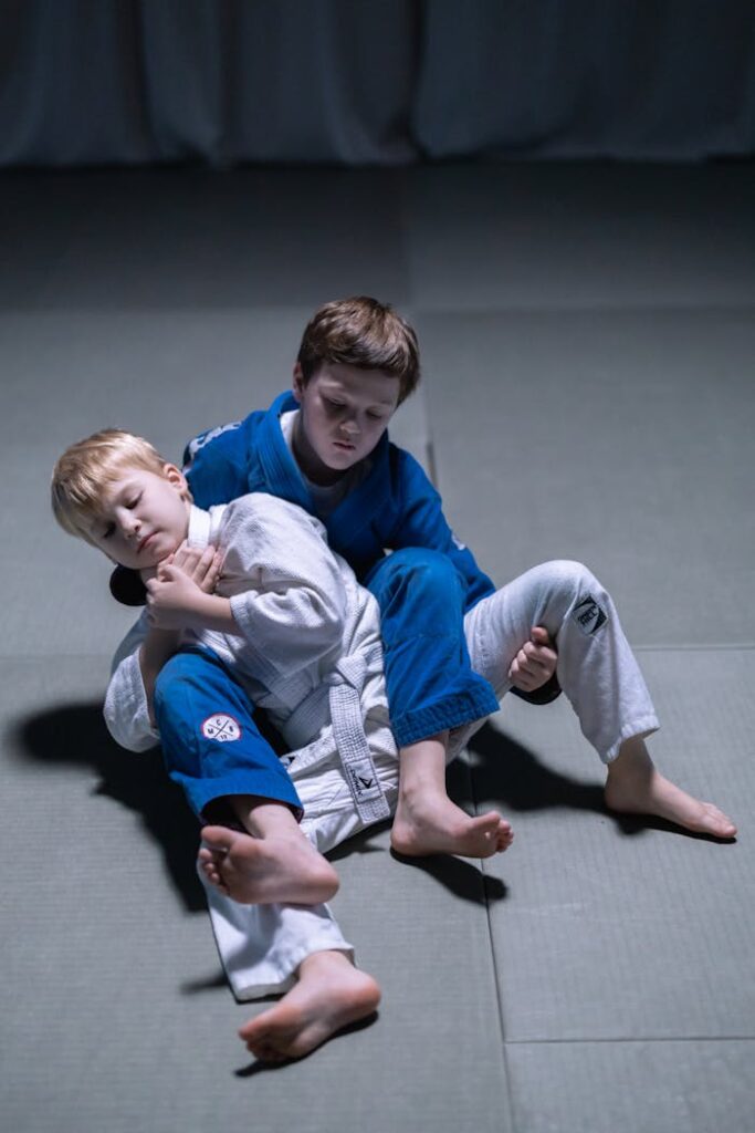 Two young boys practicing judo on mats, showcasing martial arts skills and discipline.